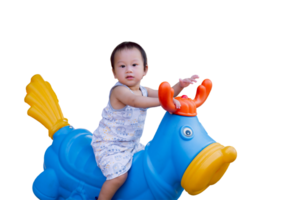 une mignonne peu garçon souriant tandis que en jouant avec une jouet printemps balancement cheval dans une Cour de récréation. content enfant dans été ou printemps temps. isolé Contexte. enfant vieilli 1.7 année vieux. png