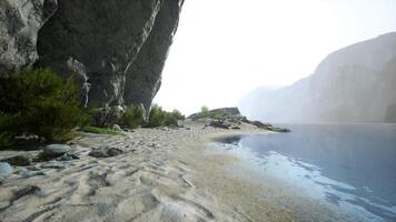 un' sereno beachscape con roccioso scogliere e cristallino acqua video