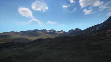 uma majestoso montanha alcance com fiapos do nuvens flutuando dentro a céu video