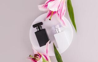 Two luxurious matte perfume bottles or sprays on a white round podium. lily. black and white bottle. masculine and feminine essence. Top view photo