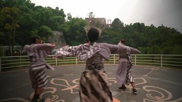 traditionell asiatisk artister i färgrik kostymer och masker engagerande i en kulturell dansa med en suddig naturlig bakgrund video