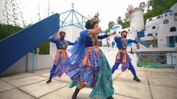 traditioneel dansers in kleurrijk kostuums het uitvoeren van buitenshuis met een wazig beweging effect, presentatie van cultureel dans bewegingen video