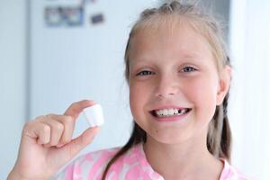 The child holds a plastic milk tooth in his hands. The concept of healthy teeth. photo