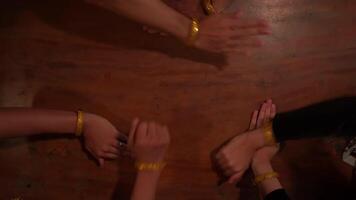 Top view of a group of people's hands joined together on a wooden surface, symbolizing teamwork and unity video