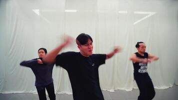 grupp av ung vuxna praktiserande dansa rör sig i en modern dansa studio med speglar och ljus belysning. video