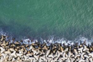 Aerial top view from drone to the seacoast with breakwater photo