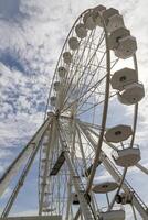 A part of the Ferris wheel against a cloudy blue sky photo