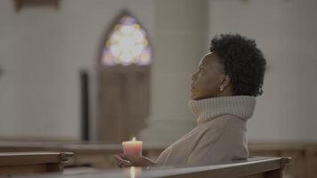 Jeune africain femme avec frisé cheveux prier à l'intérieur église video