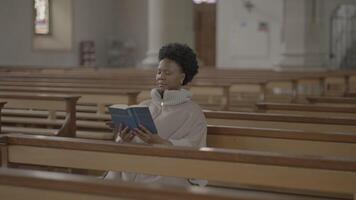 Jeune africain femme avec frisé cheveux prier à l'intérieur église video