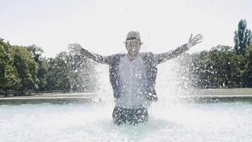 Happy Young Man Dancing in Water Fountain in Summer Time video