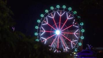 Illuminated ferris wheel shining brightly in the night video