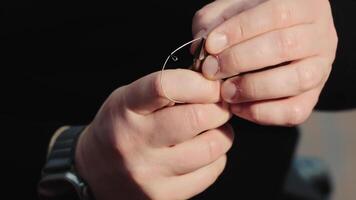 Hands holding a small dental tool, A close-up of hands holding a small dental tool, focusing on the precision and care required in dental work and orthodontic procedures. video