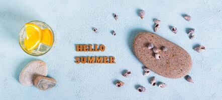 Concept hello summer text, cocktail, stones and shells on blue top view web banner photo