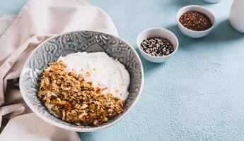 Bowl with yogurt, muesli and nuts for a healthy breakfast on the table web banner photo