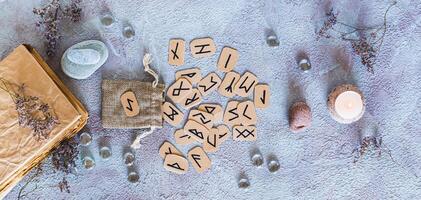 Scandinavian runes for fortune telling made of cardboard and the bag top view web banner photo