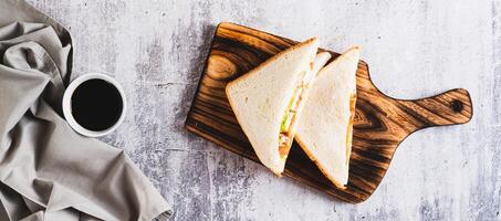 Club sandwich with chicken meat, tomato and lettuce on a board on the table top view web banner photo