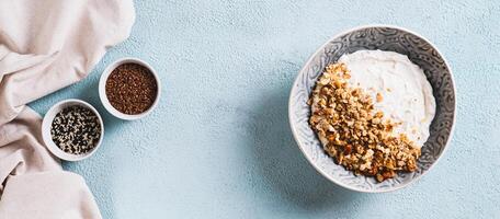 Granola with nuts in a bowl with classic yogurt for healthy eating top view web banner photo