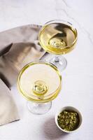 Refreshing green matcha martini in glasses on the table vertical view photo