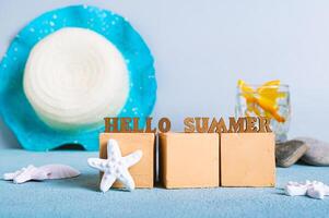 Concept hello summer text on cubes on a background of cocktail, hat and starfish photo