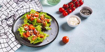 Bruschetta on rye bread with lettuce, tomatoes and sesame on a plate on the table web banner photo