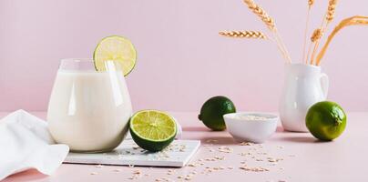 Homemade oatzempic drink of oat milk and lime in a glass on the table web banner photo