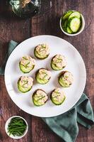 Appetizing sandwiches with pollock caviar, cucumber and herbs on a plate top and vertical view photo