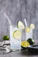 Refreshing summer mojito cocktail with ice and lime in glasses on the table vertical view photo