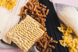 Close up of different types of pasta and noodles made from wheat, rice and buckwheat top view photo