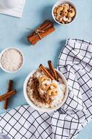 Bowl with delicious rice pudding with cinnamon and nuts on the table top and vertical view photo