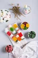 Marmalade candies-kebabs and marshmallows on skewers on the table top and vertical view photo