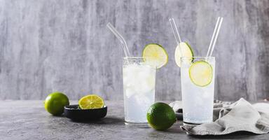 refrescante verano mojito cóctel con hielo y Lima en lentes en el mesa web bandera foto