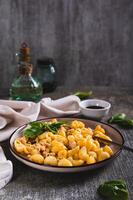 Delicious pasta with minced meat and basil on a plate on the table vertical view photo