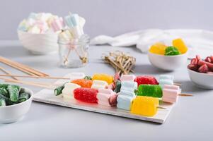 Gummy candy kabobs on skewers served on the table photo