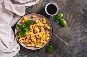 Delicious pasta with minced meat and basil on a plate on the table top view photo