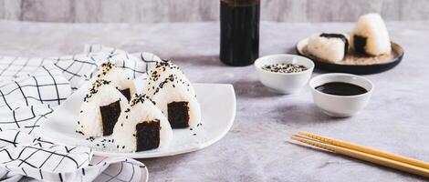 onigiri tradicional japonés comida de arroz y atún en un plato en el mesa web bandera foto