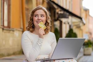 Woman using credit bank card laptop computer while transferring money purchases online shopping photo