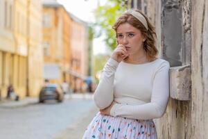 Sad unhappy frustrated young woman walking alone in city street feeling bad annoyed grief problem photo