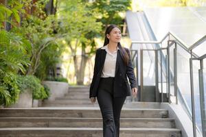 Confident businesswoman walking downstairs outdoors photo