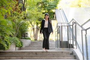 Confident businesswoman walking downstairs outdoors photo