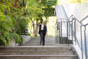 Confident businesswoman walking downstairs outdoors photo