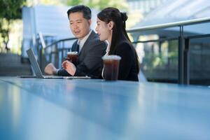 Business professionals working outdoors with laptop photo