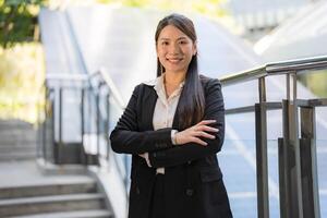 profesional mujer con un alegre sonrisa en pie por un escalera al aire libre foto