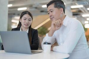 Business colleagues collaborating on laptop in office photo