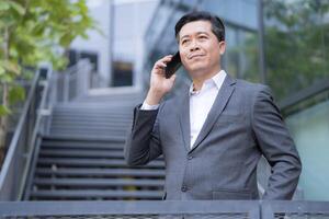 Businessman talking on phone outdoors photo