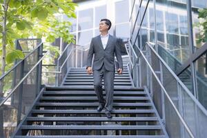 Confident businessman descending outdoor stairs photo