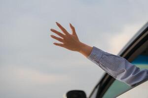 Waving hand from car window photo