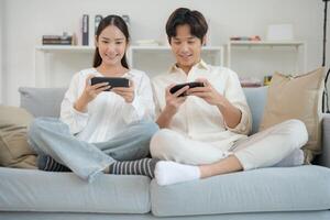 Excited young couple playing smartphone games on couch photo