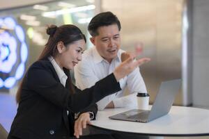 Business colleagues collaborating on laptop in office photo