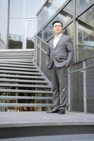 Confident businessman standing outdoors by staircase photo