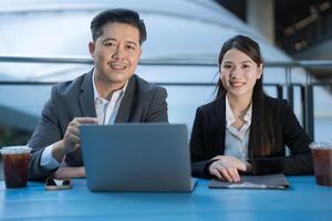 Business professionals working outdoors with laptop photo